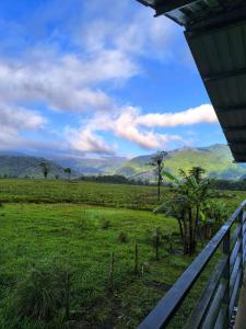 a view of a field with mountains in the background at Cabaña Cherenga in Sarchí
