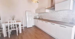 a white kitchen with a table and a white refrigerator at Fuerte Roche 2 in Tuineje