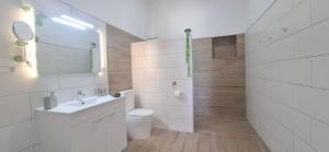 a white bathroom with a toilet and a sink at Fuerte Roche 2 in Tuineje +28 photos