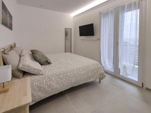 a bedroom with a bed and a large window at Ad un passo dal mare apartment in Molfetta