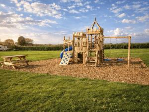 a playground with a slide and a bench at Alpaca Hideaway in Llanstadwell +28 photos