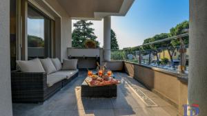 a patio with a couch and a table on a balcony at Oscar Luxury Suite DesenzanoLoft Official Partner Homes & Villas by Marriott Bonvoy in Desenzano del Garda