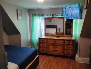 a bedroom with a dresser with a mirror and a tv at Grove 125 in Irvington