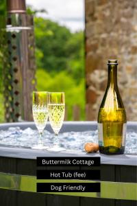 a bottle of wine and two glasses on a table at Puddleduck Valley - Dog Friendly in Holsworthy