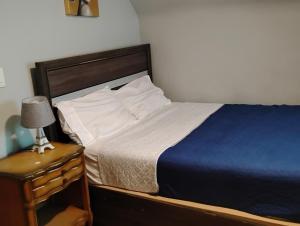 a bedroom with a bed and a night stand with a lamp at Grove 125 in Irvington