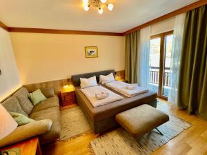 a living room with a bed and a couch at Gästehaus Wallner in Presseggen