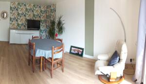 a living room with a table and chairs and a couch at le Questel in Plouézec