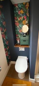 a bathroom with a toilet with a flower wallpaper at The Pentland Apartment in Penicuik +41 photos