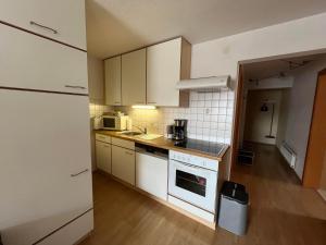a kitchen with white cabinets and a stove top oven at Haus Alpenblick in Bichlbach