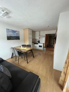 a living room with a dining room table and a kitchen at Haus Alpenblick in Bichlbach