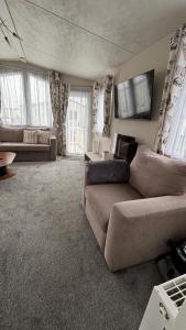 a living room with a bed and a couch at WillowWay168, Tranquility Family Home in Camber