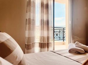 a bedroom with a bed and a window with a view at Seafront Central Luxury Apartment in Samos
