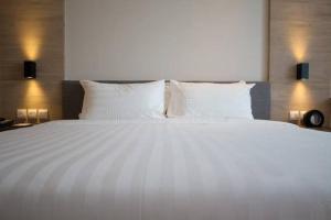 a large white bed with white pillows in a bedroom at Pousada Gran-Café in Quixadá