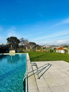 a swimming pool with a chair sitting next to it at Skyline Heaven - Fantastic View - Pool - Garage in Vila Nova de Gaia
