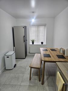 a kitchen with a wooden table and a refrigerator at The Brown Rest House in Gravesend