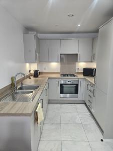 a kitchen with white cabinets and stainless steel appliances at The Brown Rest House in Gravesend