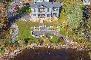 an aerial view of a house with a pond at charming riverside retreat in Huntsville +29 photos