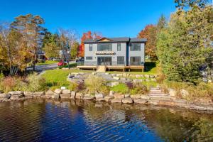 a large house by the water in front of a house at charming riverside retreat in Huntsville