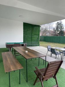 a group of tables and chairs with a ping pong table at Apartman na dan Pecinci in Pećinci