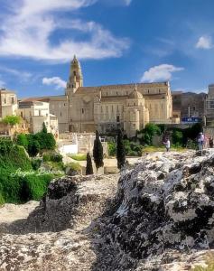 a large building in the background with people walking in front at B&B Sotto l'Arco nel Cuore del Centro Storico in Gravina in Puglia