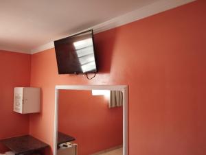 a television on the wall of a bathroom at Motel pousada Zafira in Salvador