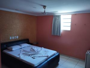 a bedroom with a bed in a room with a window at Motel pousada Zafira in Salvador
