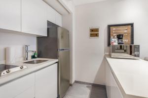 a white kitchen with a sink and a microwave at Swim-up 1-bedroom apartment in Playa del Carmen