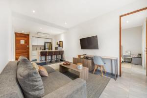 a living room with a couch and a kitchen at Swim-up 1-bedroom apartment in Playa del Carmen