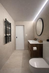 a bathroom with a white toilet and a mirror at Escala in Fully +29 photos