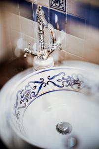 a white bathroom sink with a silver design on it at B&B Lo Gnomo in Pennapiedimonte