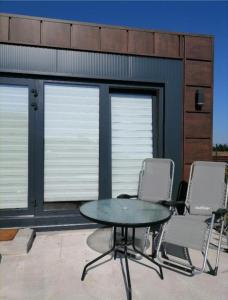 a patio with a table and chairs in front of a building at Pas Alksnius in Rotuliai