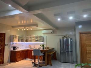 a kitchen with a stainless steel refrigerator and a wooden table at Shella Home Stay in Miagao