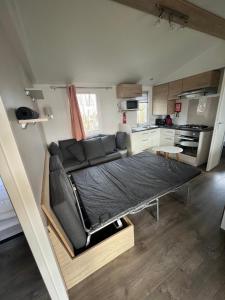 a room with a bed and a couch in a kitchen at Mobil Home Litteau Calvados in Litteau