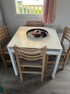 a table and chairs with a plate on top of it at Mobil Home Litteau Calvados in Litteau +7 photos