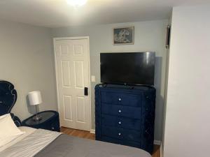 a bedroom with a bed and a television on a dresser at Grove 3- King Bed with Private Bathroom in Irvington