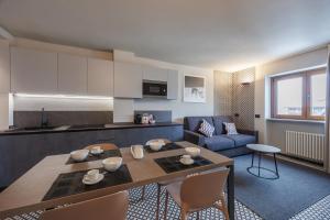 a kitchen and living room with a table and a couch at Central Guest in Sauze dʼOulx
