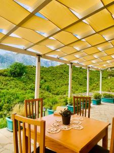 a wooden table and chairs on a patio with a view at Oda Tozaj in Kallarat