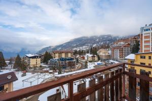 a view from a balcony of a city in the snow at Central Guest in Sauze dʼOulx