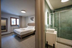 a bedroom with a bed and a shower and a sink at Central Guest in Sauze dʼOulx +35 photos