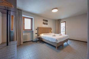 a bedroom with a large bed and a window at Central Guest in Sauze dʼOulx