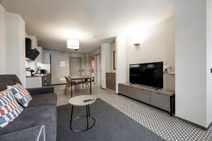 a living room with a couch and a flat screen tv at Central Guest in Sauze dʼOulx