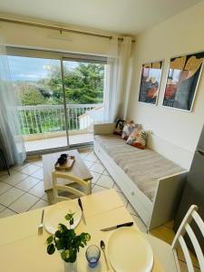 a living room with a couch and a table at Les Pins Marins, Proche plages in Saint-Jean-de-Monts