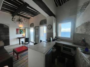 a kitchen with a counter and a living room at Fleur de Falaise in Bonifacio