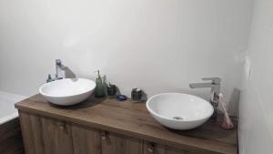two sinks on a wooden counter in a bathroom at Harmony Apartman in Otilia