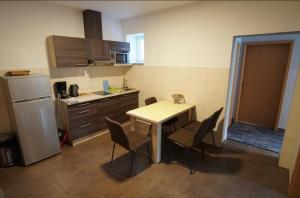 a kitchen with a table and chairs and a refrigerator at Pension Am Pilgerbach in Baunatal