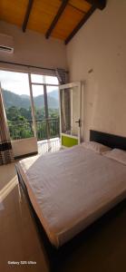 a large bed in a room with a large window at X38 Venture in Kitulgala