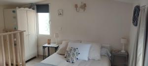 a white bedroom with a bed and a window at Le refuge de Teddy in Solliès-Toucas