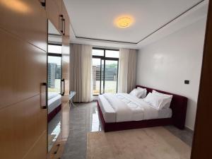 a bedroom with a bed and a large window at Beza Residence in Ruhengeri