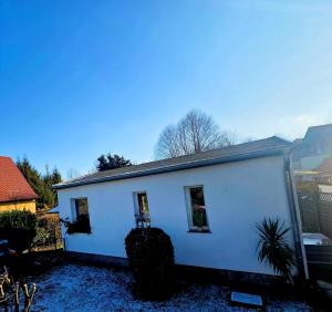 a white house with two windows on the side of it at Ferienhaus am Tänntalbach in Öhrenfeld