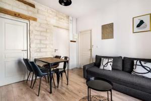 a living room with a couch and a table at Comédie ST-Roch - T2 - Hypercentre Gare - CLIM & NETFLIX in Montpellier